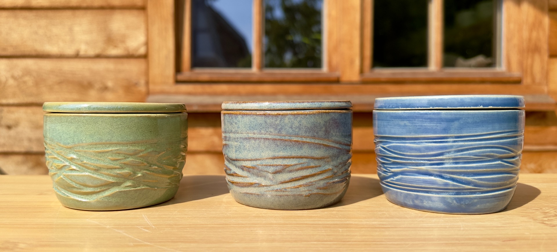 Drie keramische Bretoense boterpotten met glazuur in groen, grijs en blauw